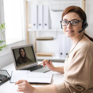 retrato de mujer en el trabajo con videollamada en portatil