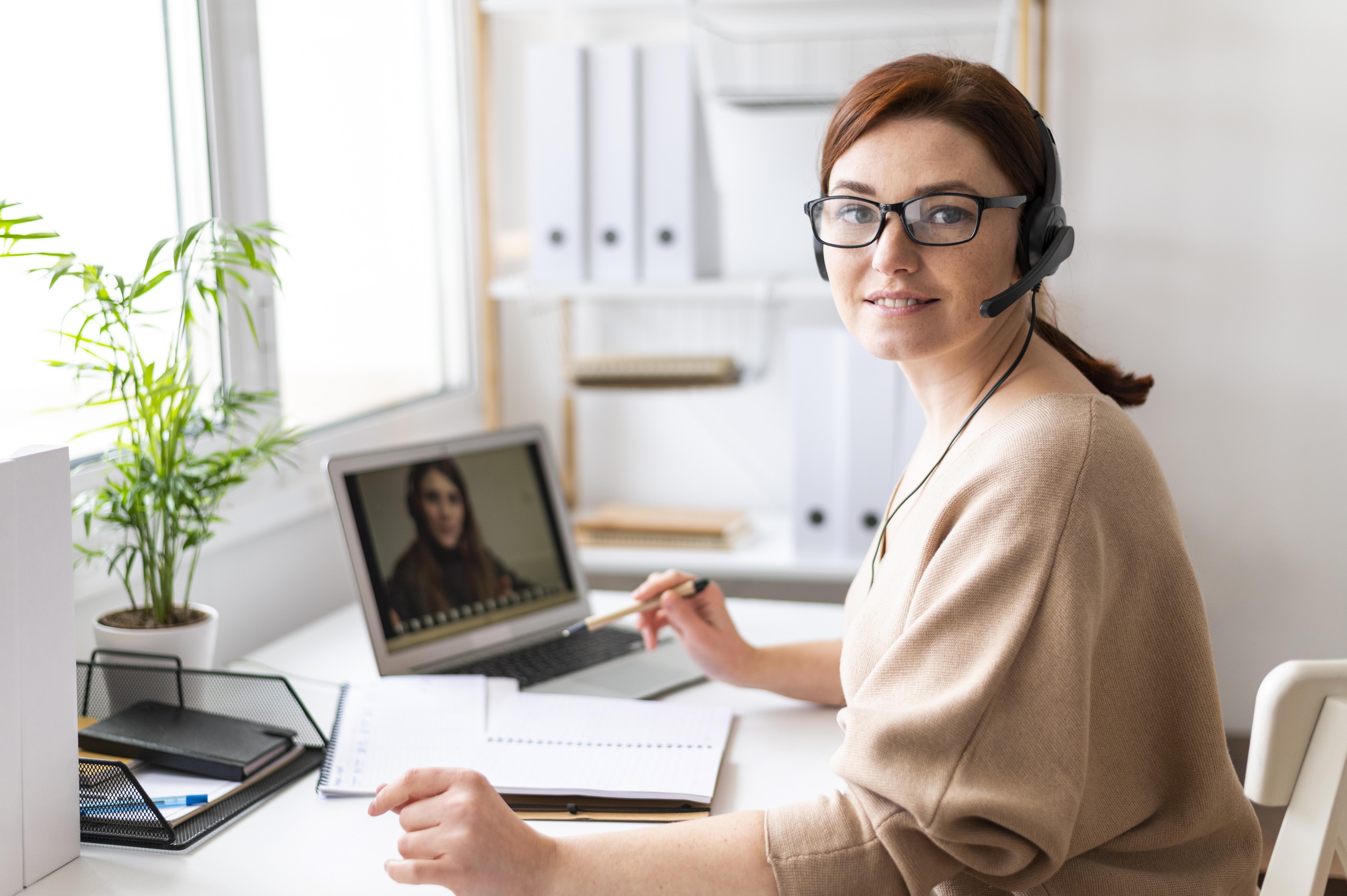 retrato de mujer en el trabajo con videollamada en portatil